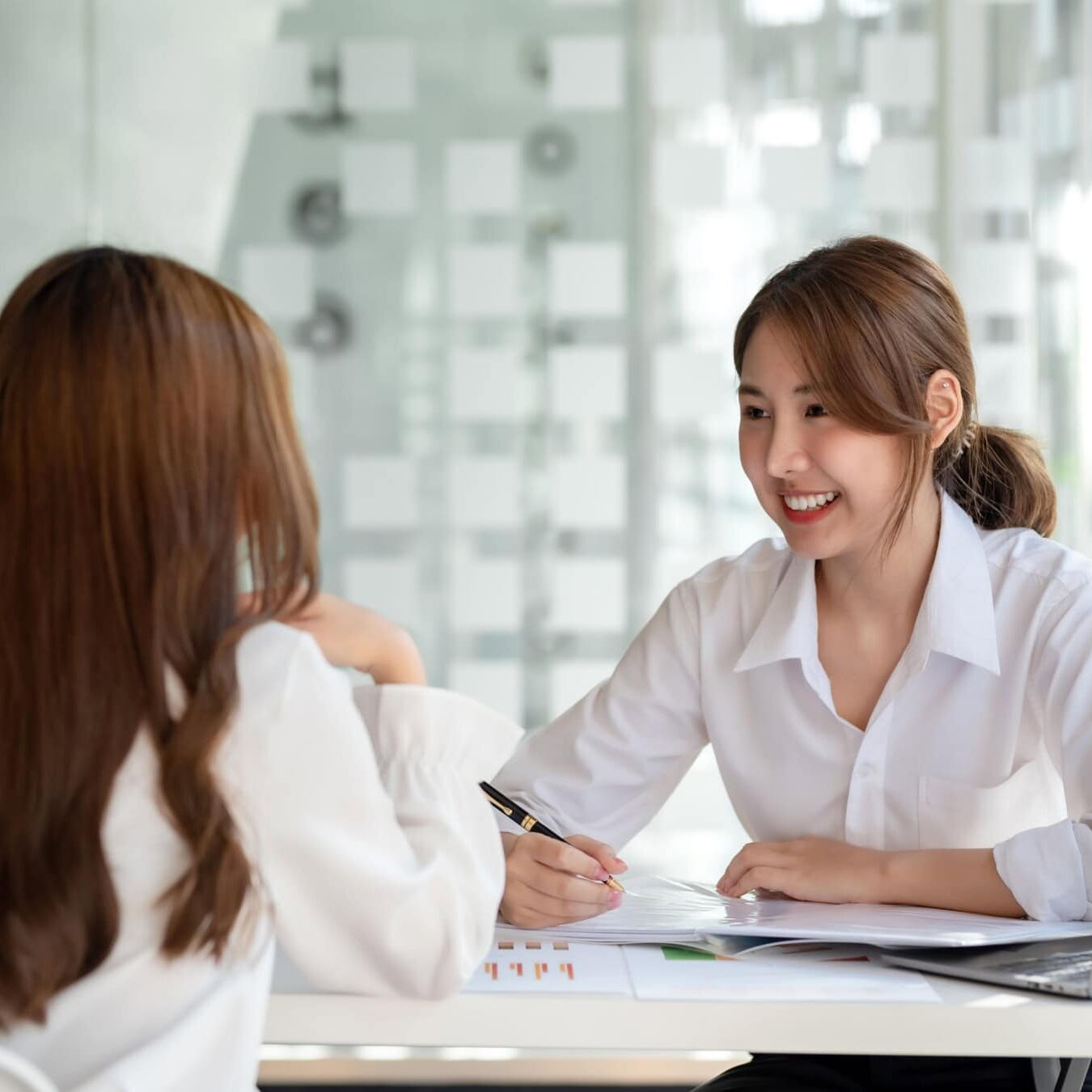 Two women go over the latest ESG report from ICF.