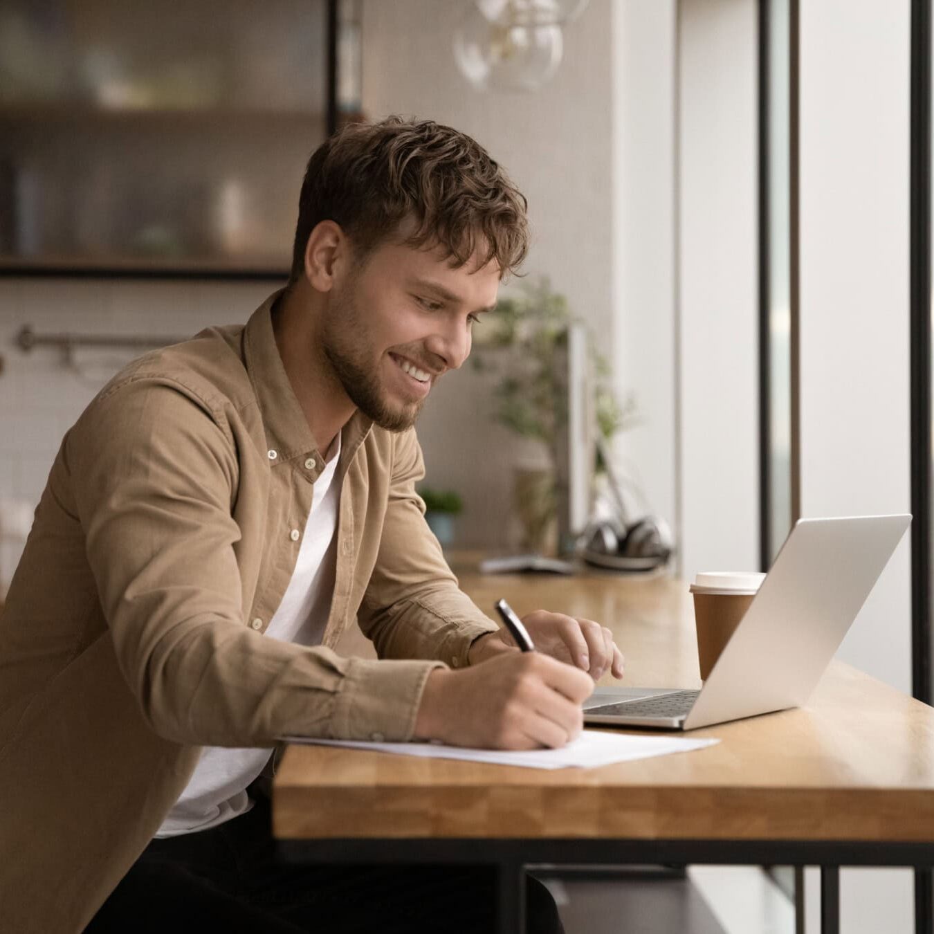 A man looks through his computer viewing the coaching education paths for credential applications