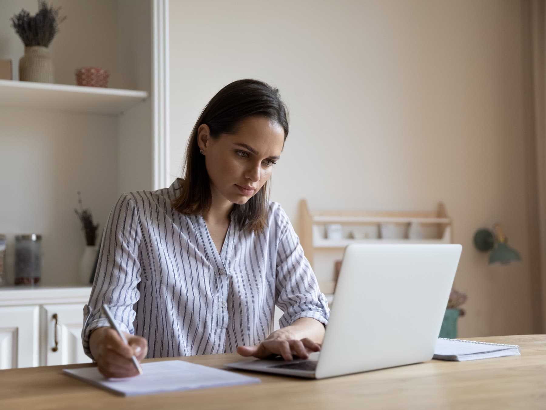 A woman works on her computer to prepare for the credential application