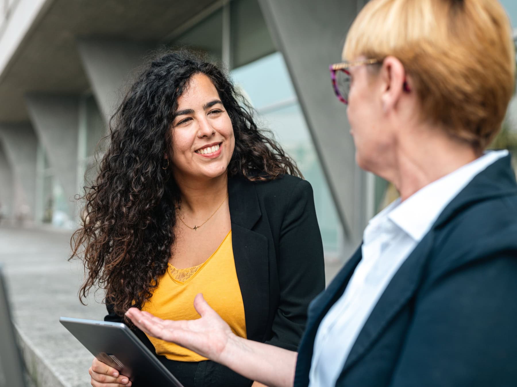 Two people compare the ICF Coaching credentials outside with an Ipad