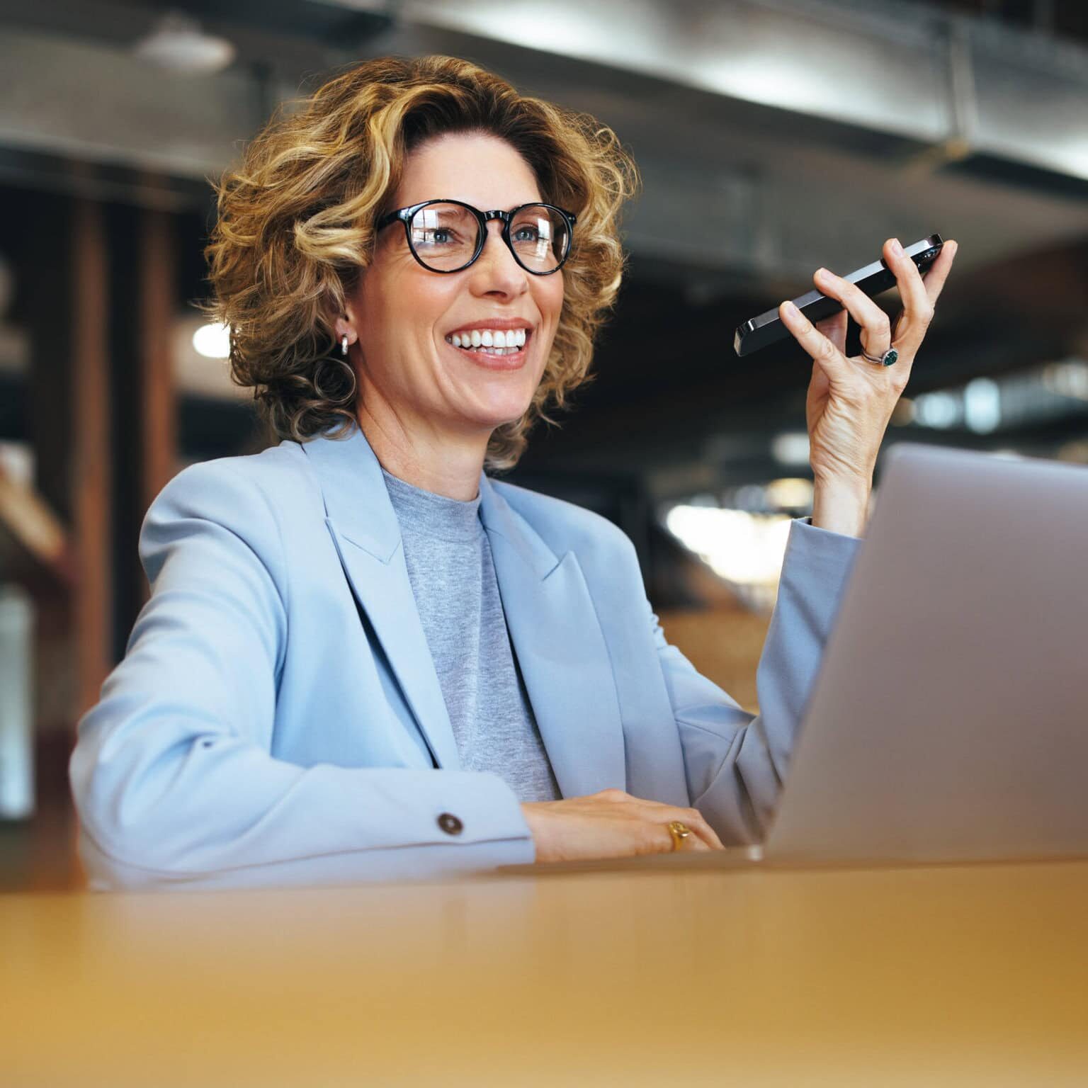 Businesswoman smiling while on the phone discussing coach credentials and standards.