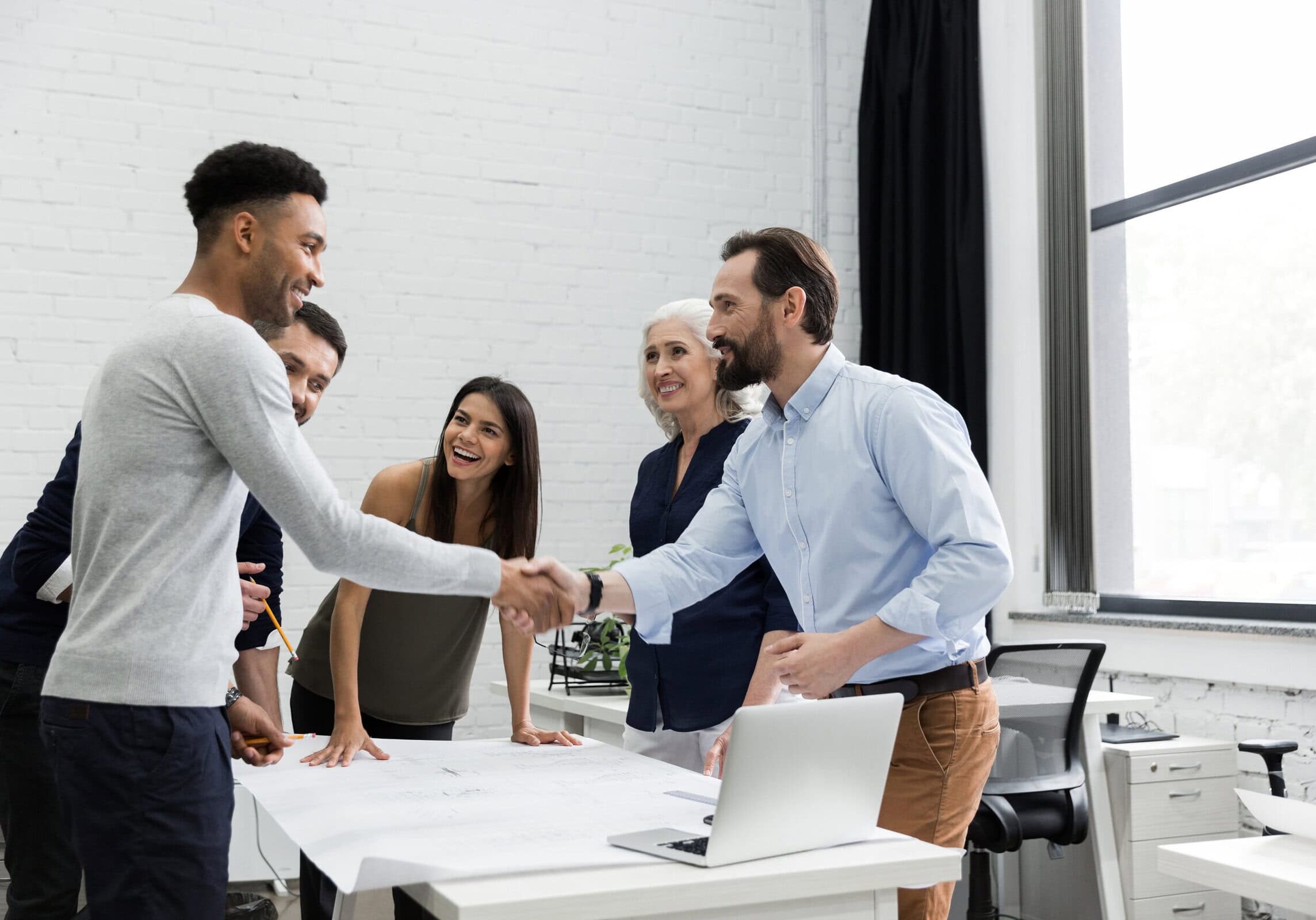 A diverse group of professionals collaborating in a coach team meeting at the office, highlighting ICF's focus on professional development.