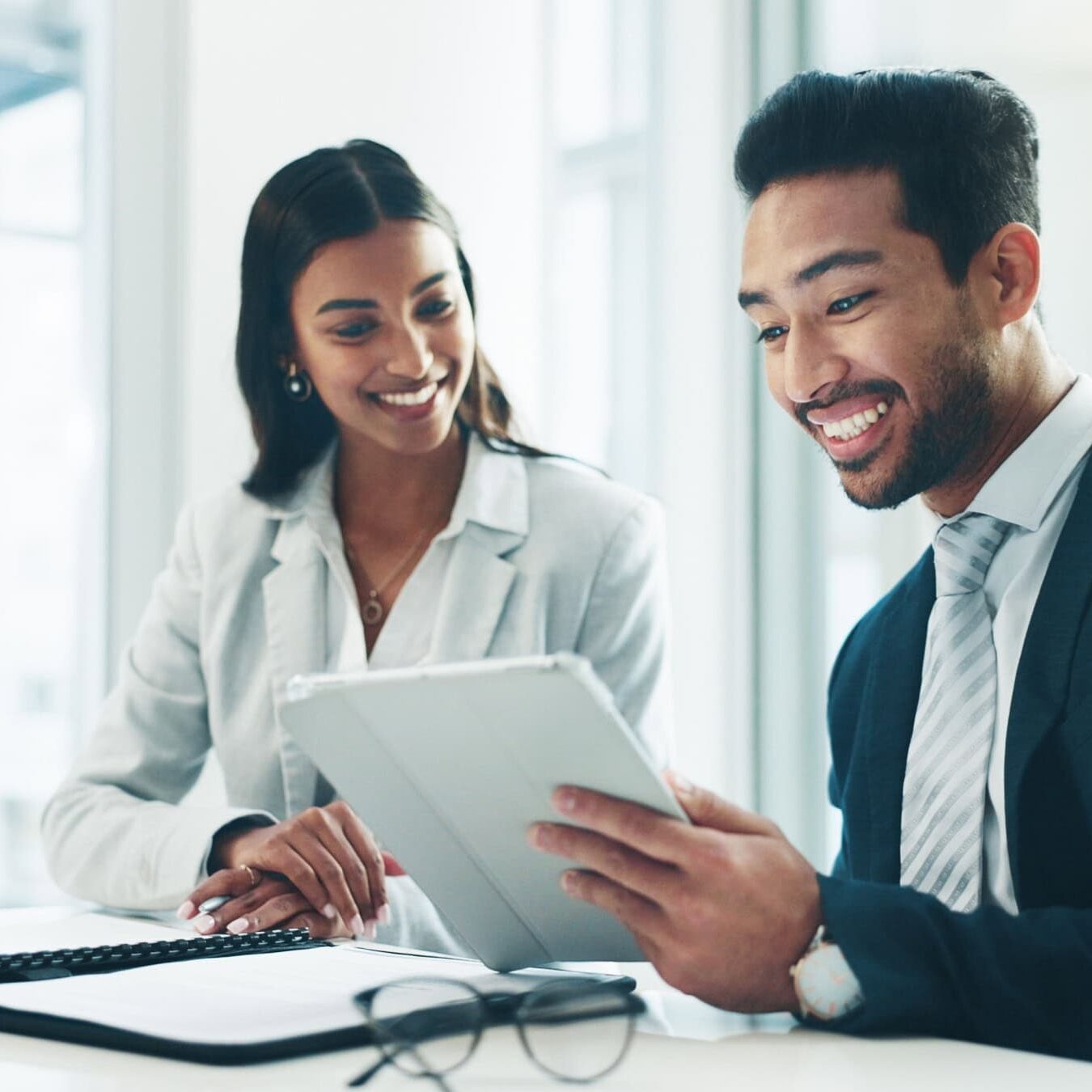 Two people use a tablet to explore research from ICF