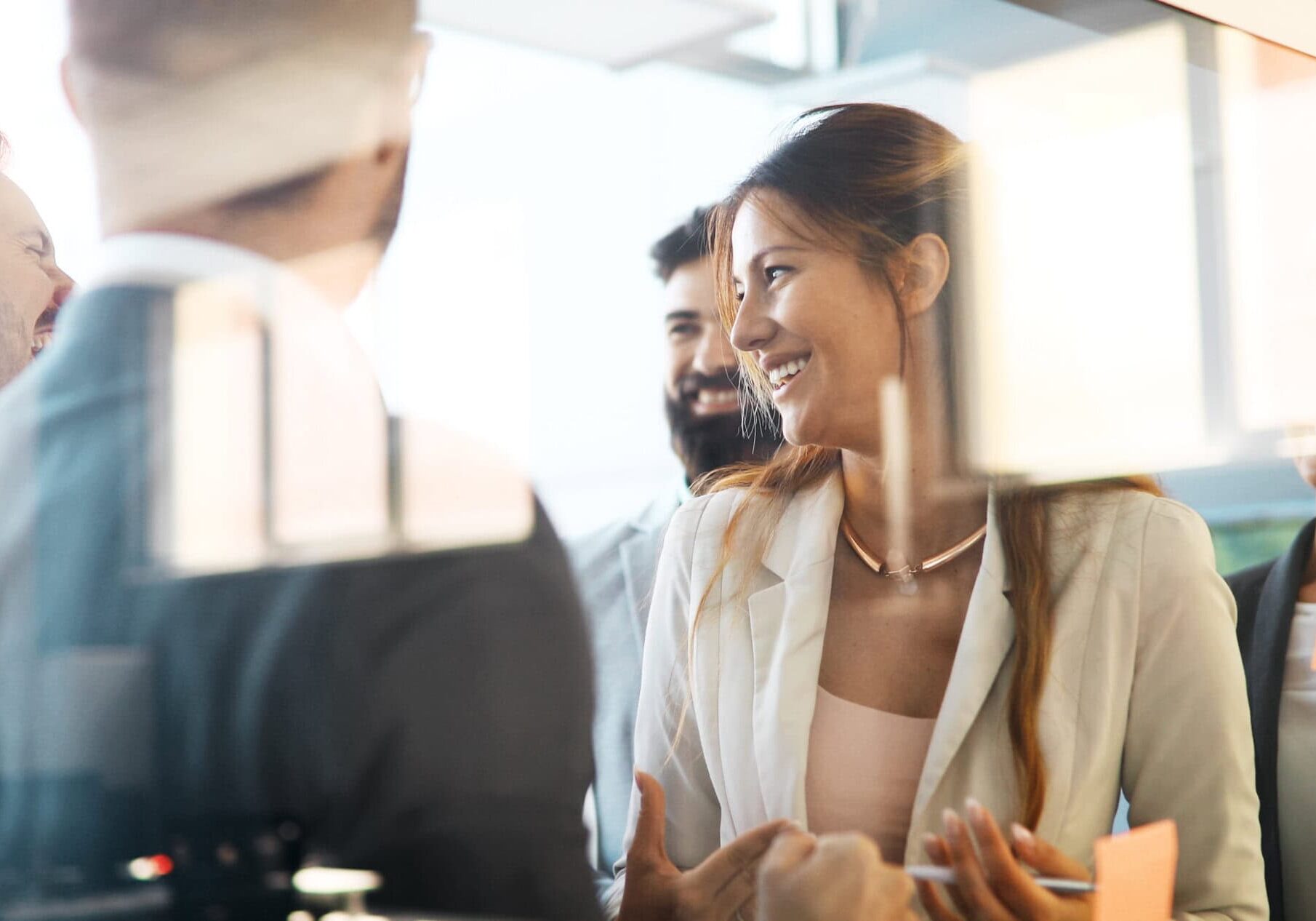 Two professionals, a man and a woman, discussing their professional coaching journeys in a bright office.