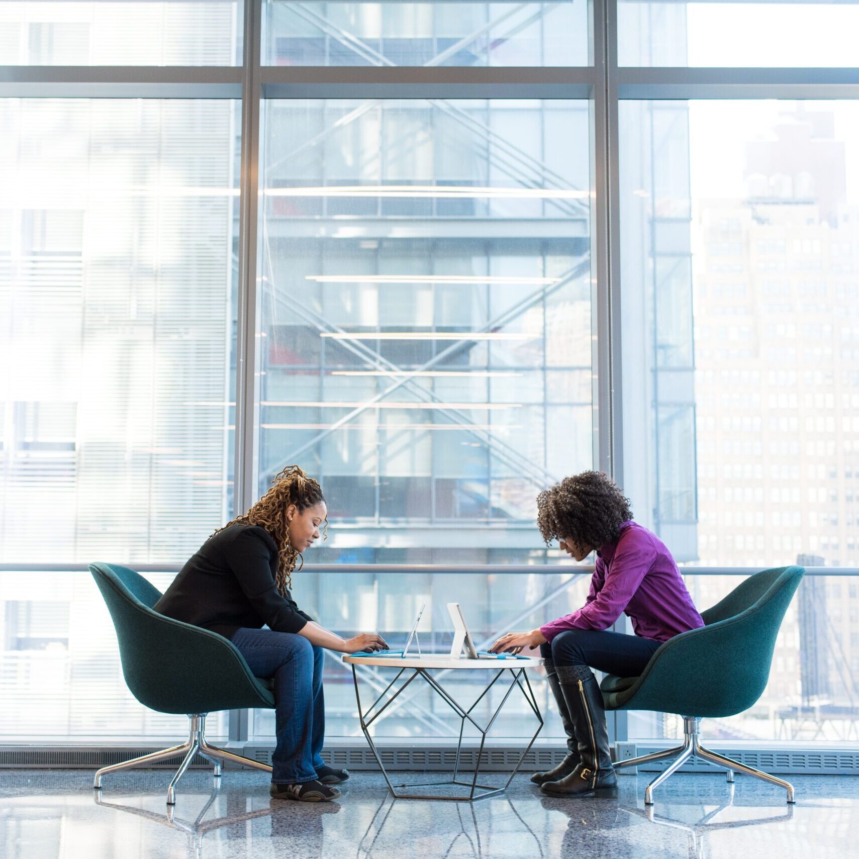 Two women work together on their plan in a quiet office building